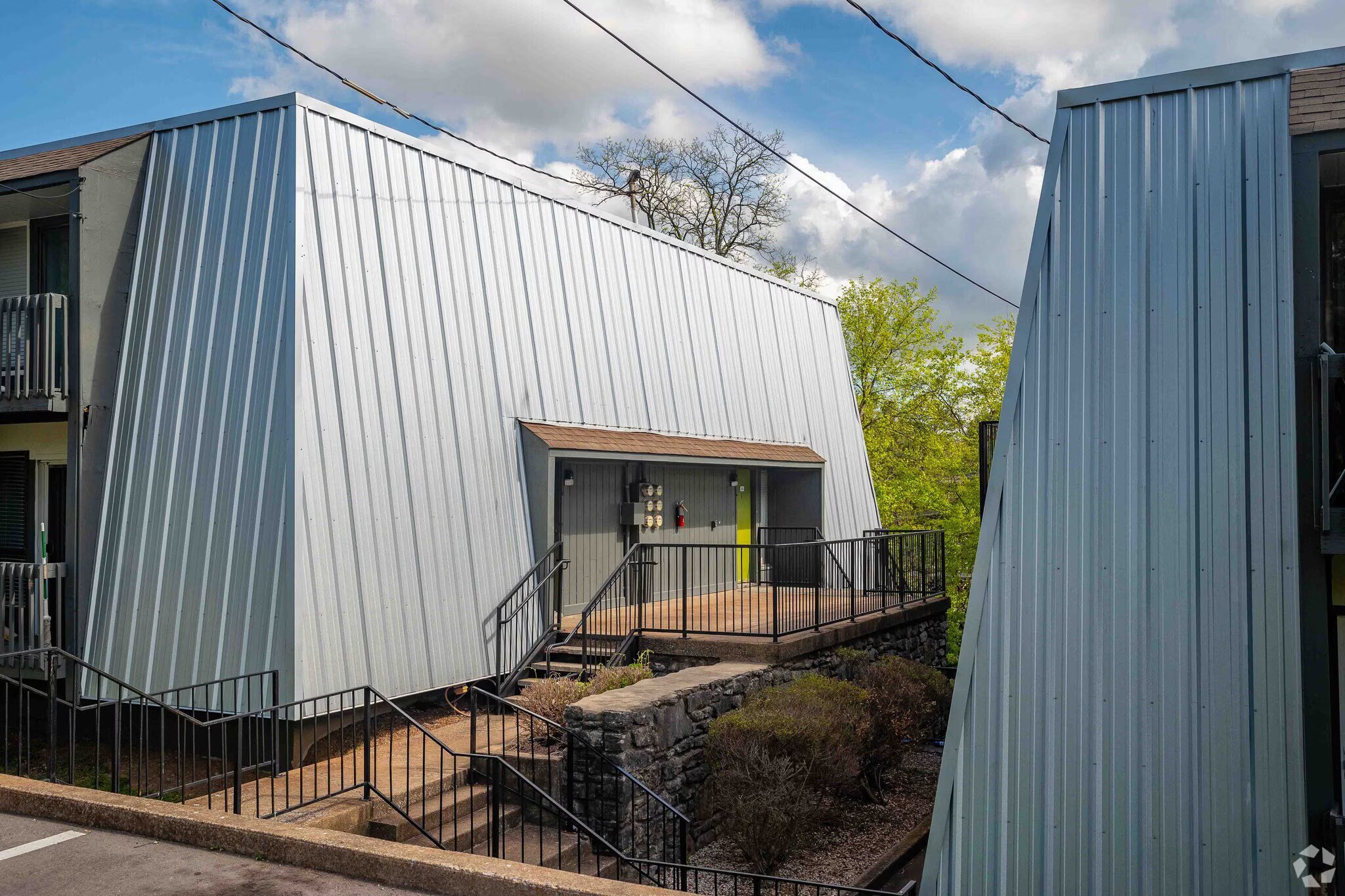 A modern house with a metal roof and a balcony.